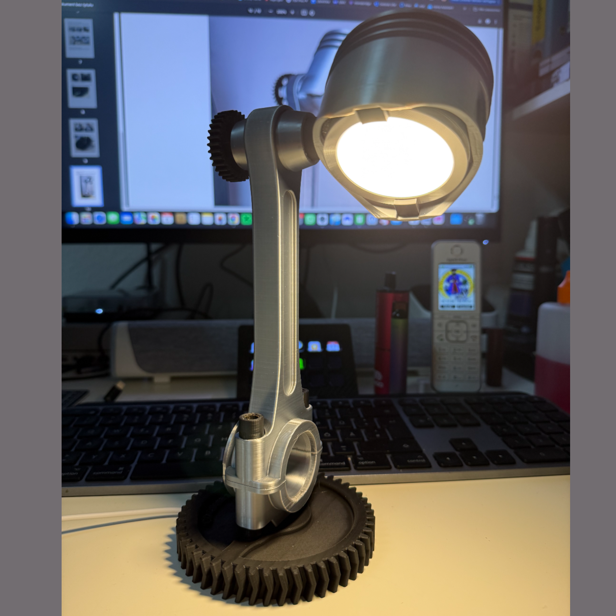 Desk lamp with mechanical design on a desk in front of a computer screen