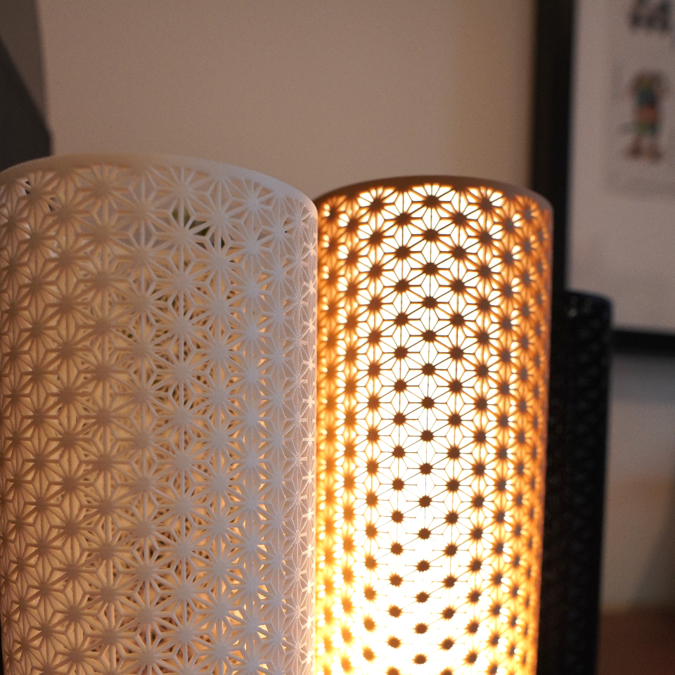 Two decorative lamps with intricate patterns on a wooden surface.
