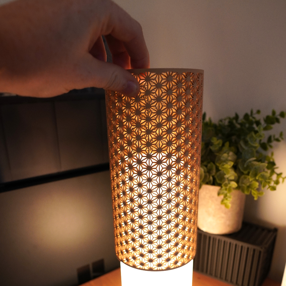 Decorative table lamp with a patterned shade on a wooden surface.