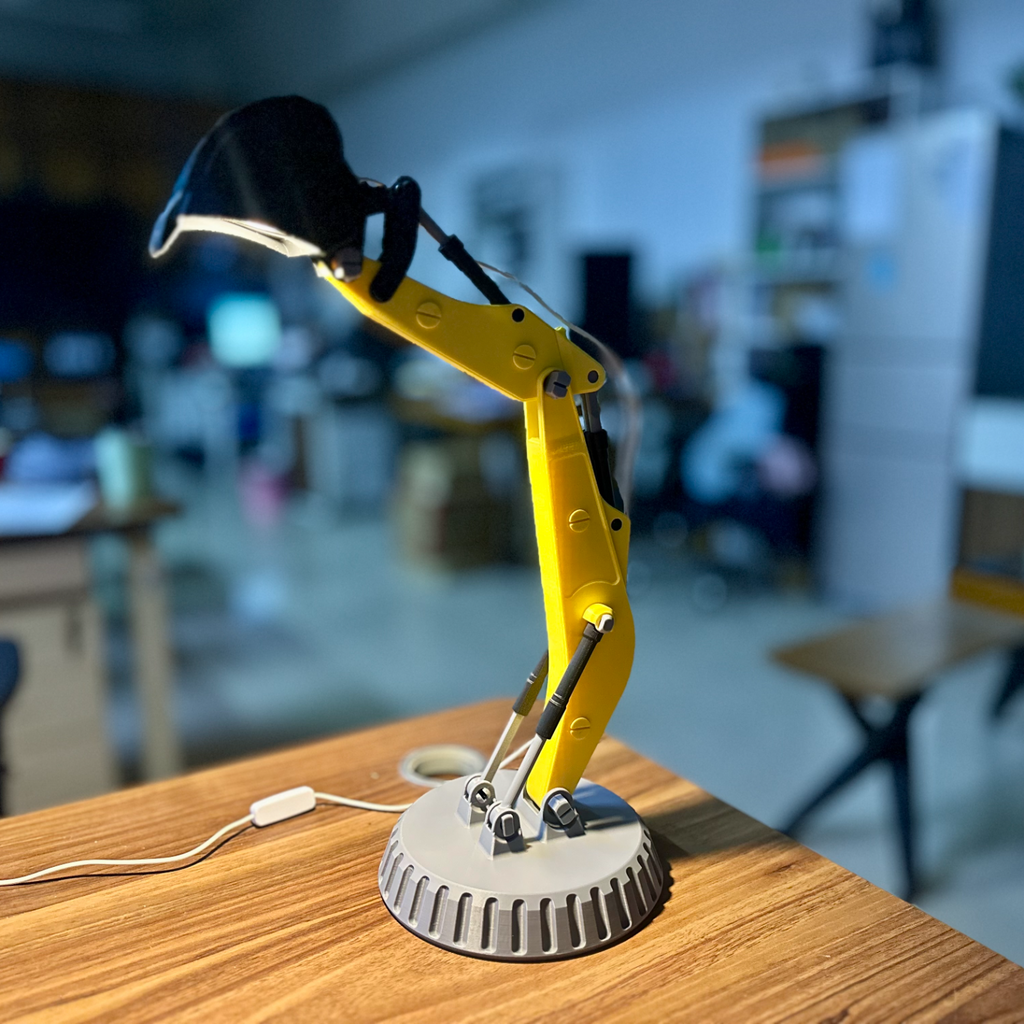 Yellow robot arm lamp on a wooden surface with a blurred office background